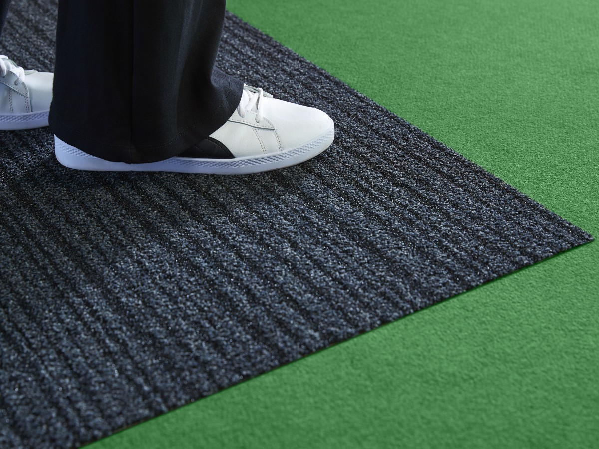 Eine Person steht mit zwei Schuhen auf einem Sauberlauf