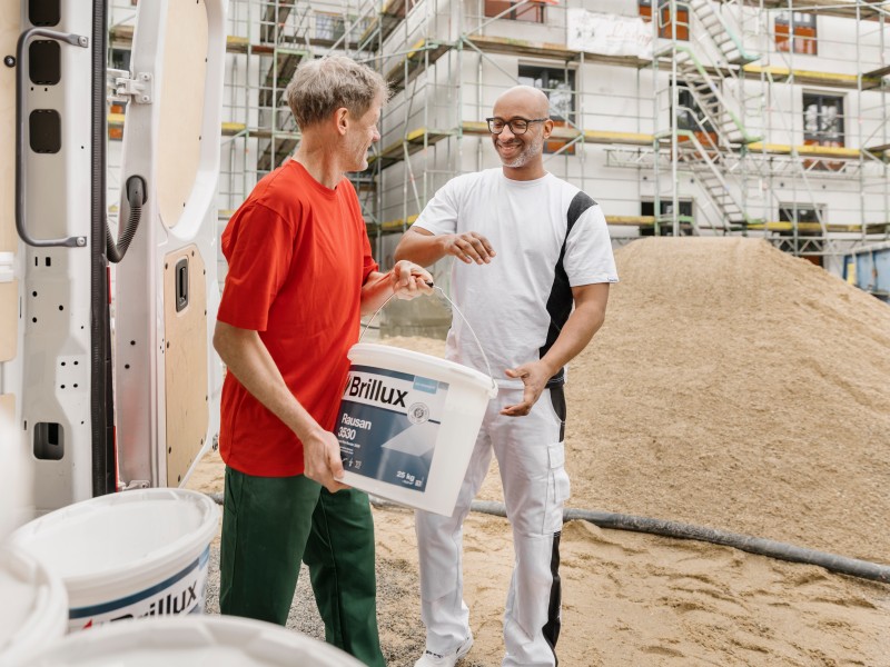 Zusammenarbeit auf der Baustelle: Brillux-Lieferant übergibt Maler Farbmaterial