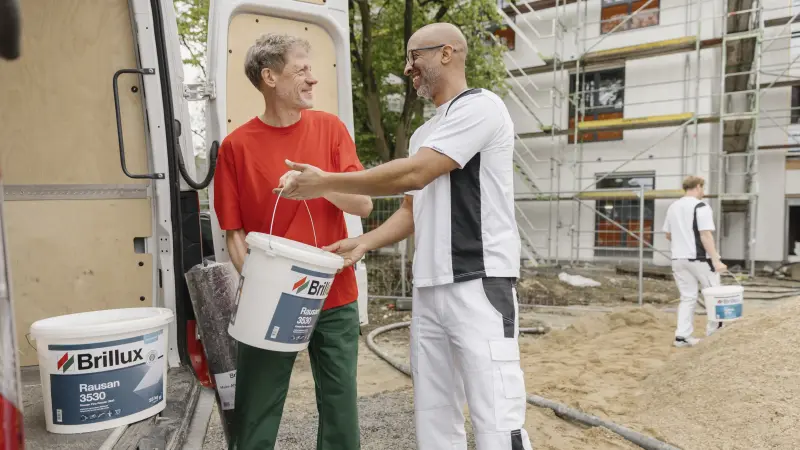Two painters and a consultant walking through a construction site together