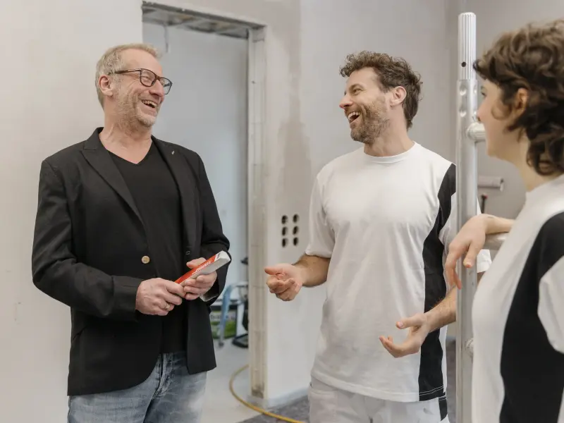 2 Maler und ein Bauleiter lachen