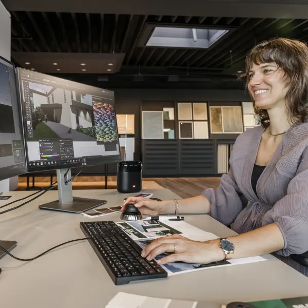Frau arbeitet an 2 Bildschrimen