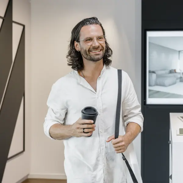 Mann steht lächelnd in einem Büro