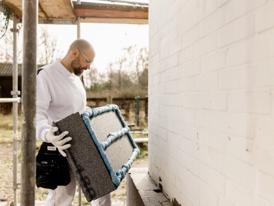 Maler an Hauswand mit Dämmplatte
