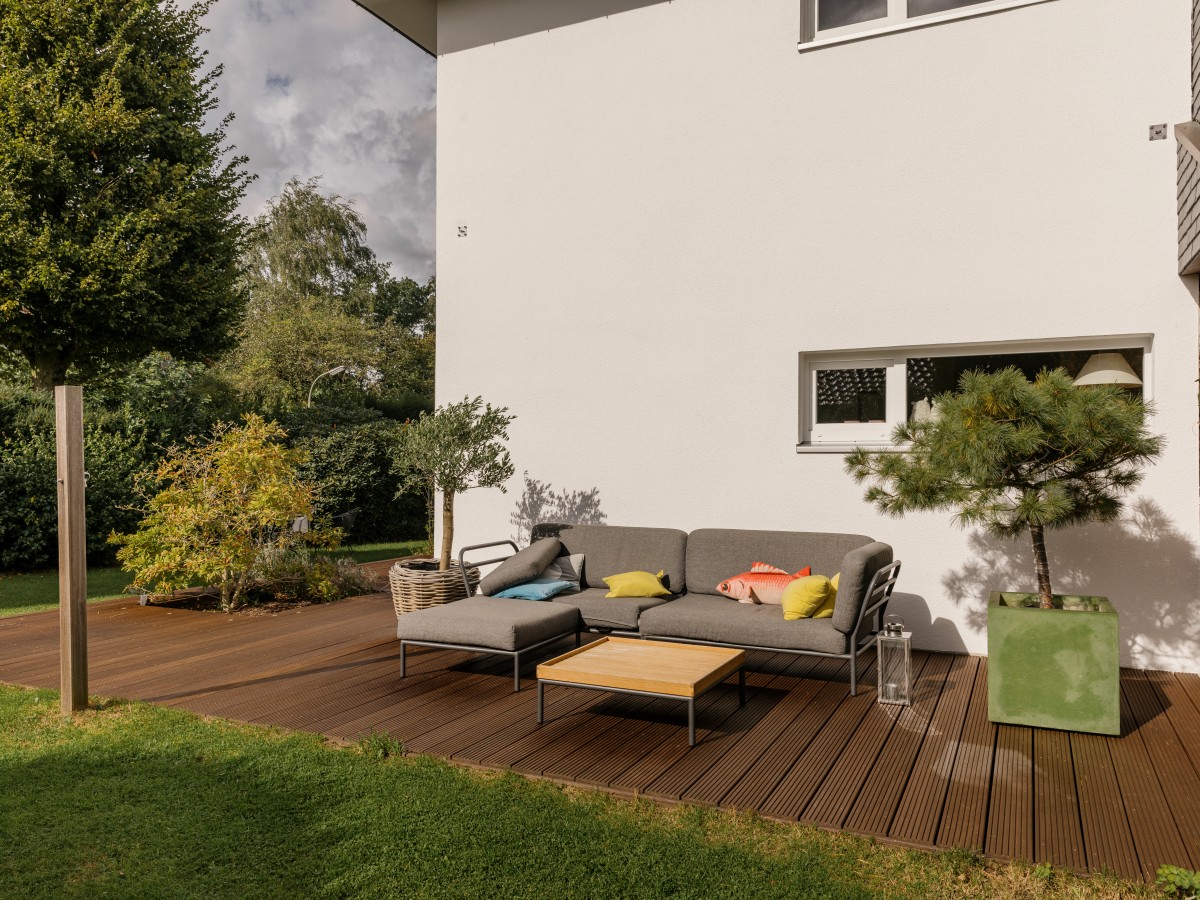 Holzterrasse vor hellem Haus