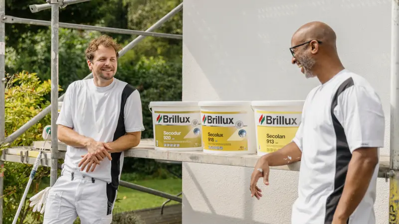Foto van twee schilders met de producten voor een gevel