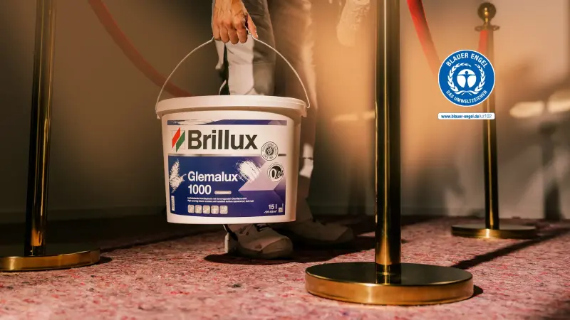 Eine Hand hält einen Brillux Glemalux Farbeimer