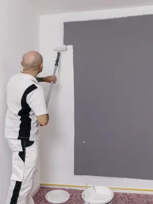 Eine graue Wand wird weiß überstrichen 