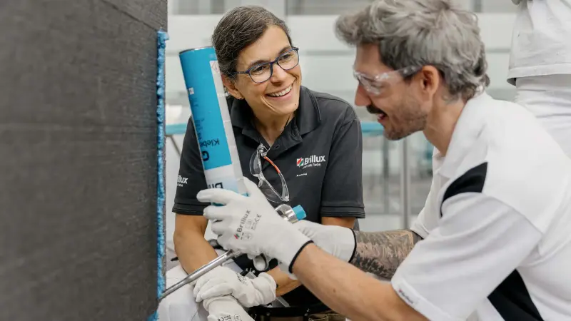 Ein Maler verarbeitet Lignodur in grün getönt an einer Holzwand