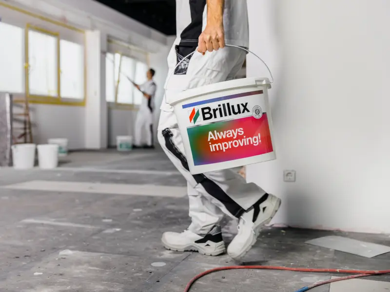 Painter carrying paint bucket on construction site