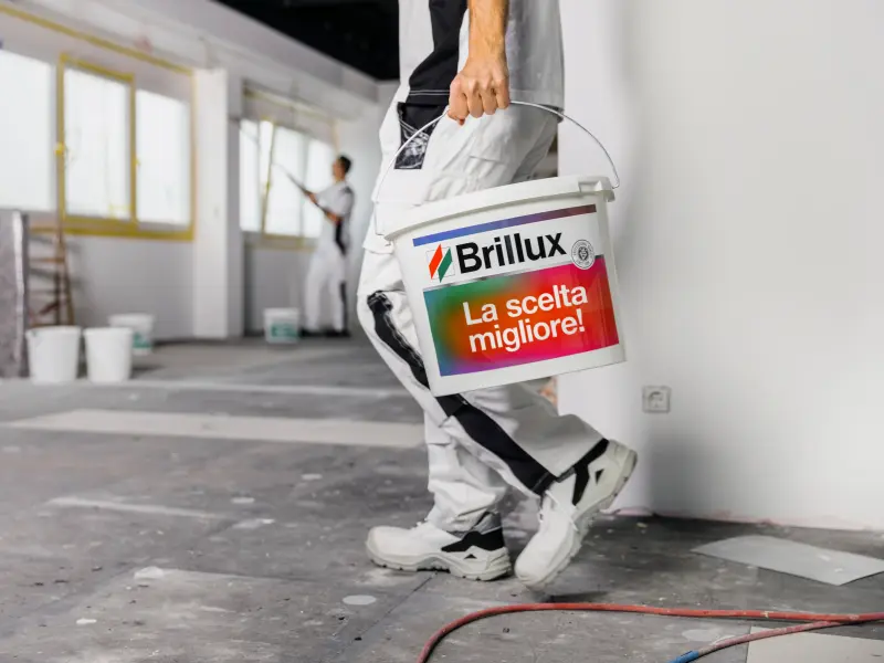 Un imbianchino trasporta un secchio di pittura in cantiere