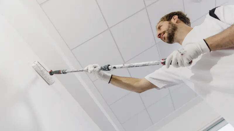 ein Mann malt eine Wand