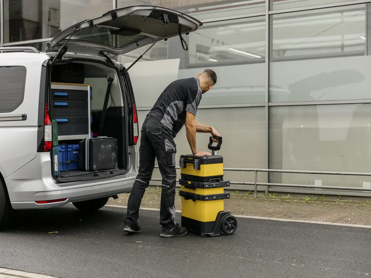 Mann räumt Brillux Farbsystem ins Auto