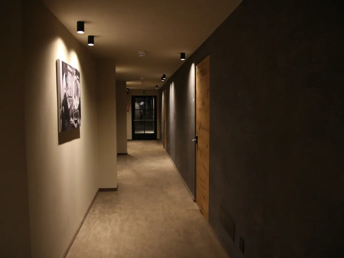 Corridoio dell'hotel color marrone scuro con lampade a soffitto