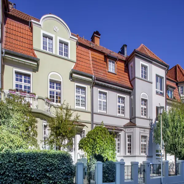 beige und lila gestrichenes Haus nebeneinander