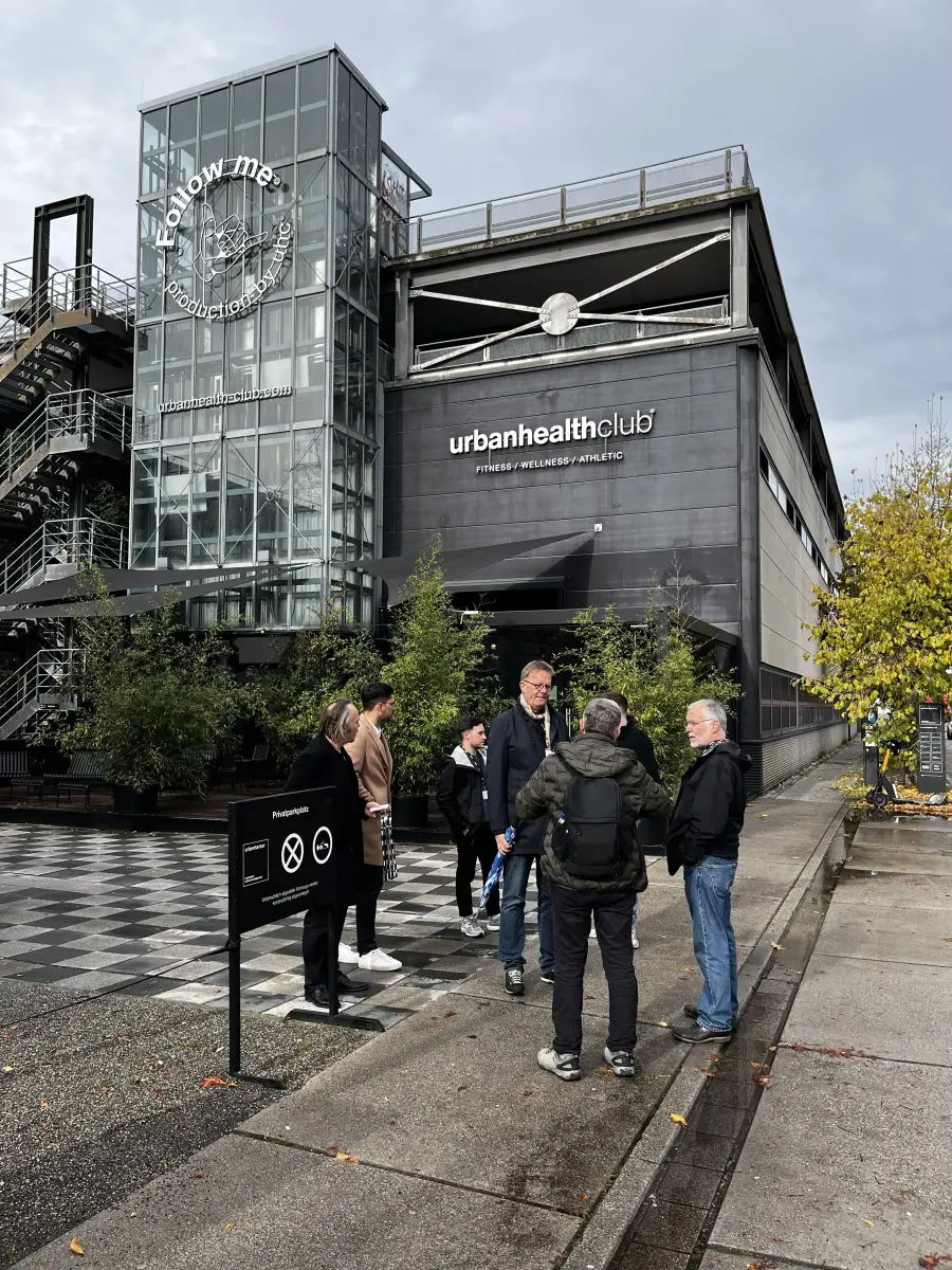 Eine Gruppe von Menschen steht vor dem Gebäude des "Urban Health Club".