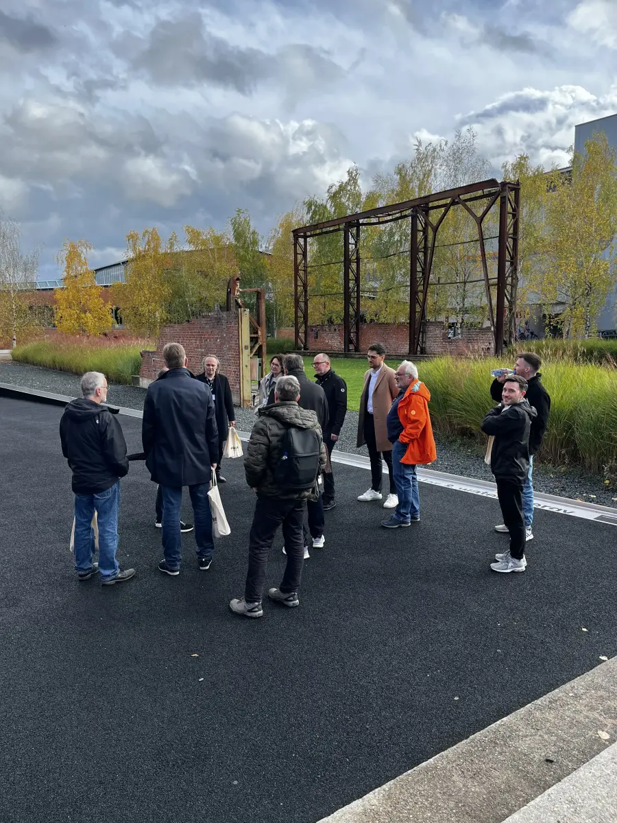 Eine Gruppe von Menschen steht draußen auf einer Straße.