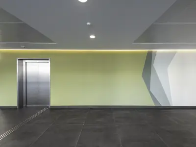 Eingangsbereich Klinik mit gelber Wand und Fahrstuhl