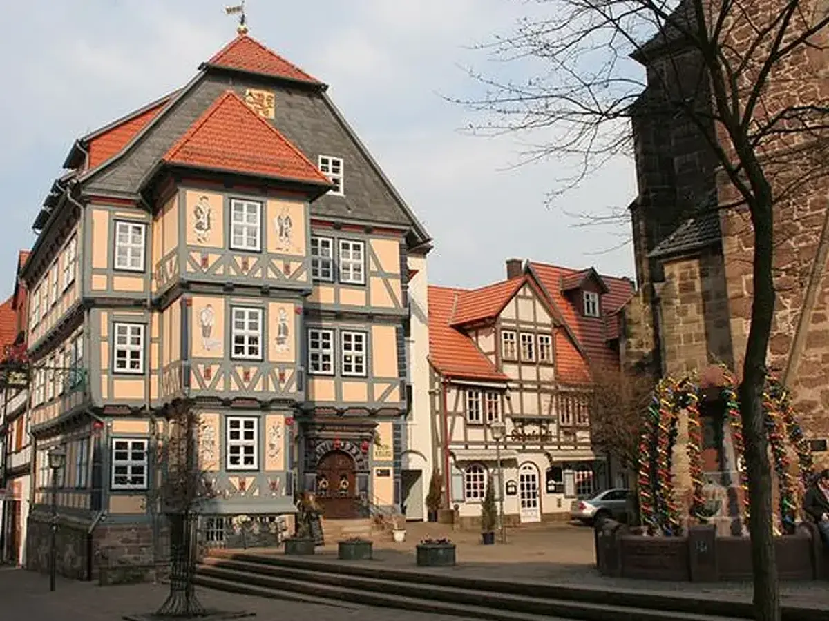 ocker farbenes Fachwerkhaus gegenüber von gotischer Stadtkirche