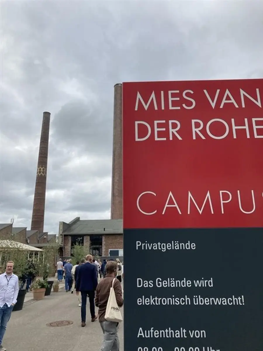Großes hohes rotes Schild vor dem Campus