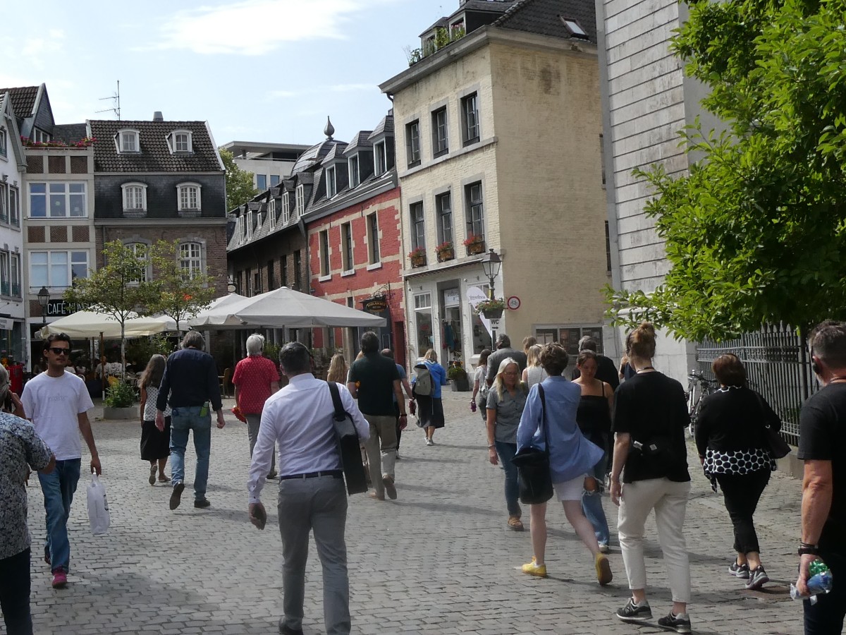 Eine Gruppe von Menschen läuft durch die Altstadt von Aachen.