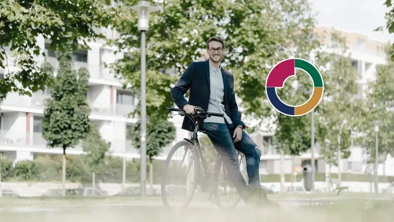 Ein junger Mann sitzt auf einem Fahrrad in begrünter Umgebung