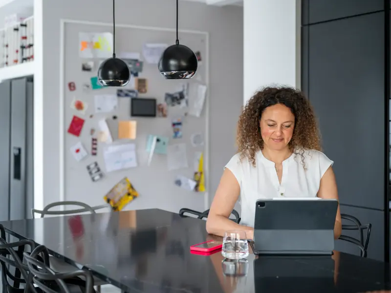 Frau sitzt in der Küche vor Laptop