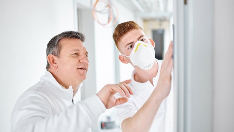Maler und Auszubildender bei der Arbeit