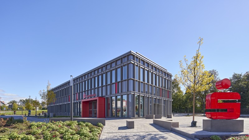 Sparkassensymbol in rot steht vor Sparkassengebäude in Stadtallendorf