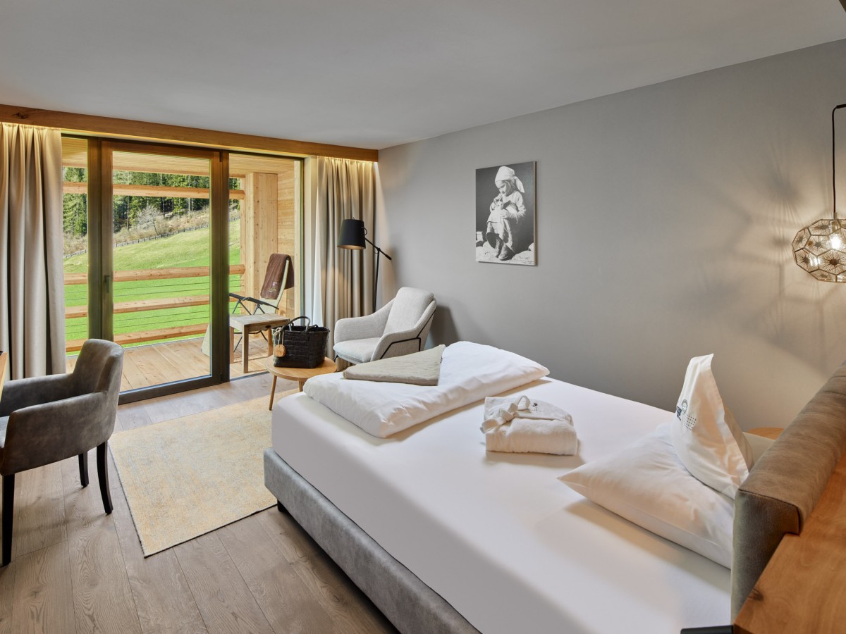 Hotelzimmer in Holzoptik und weißes Bett