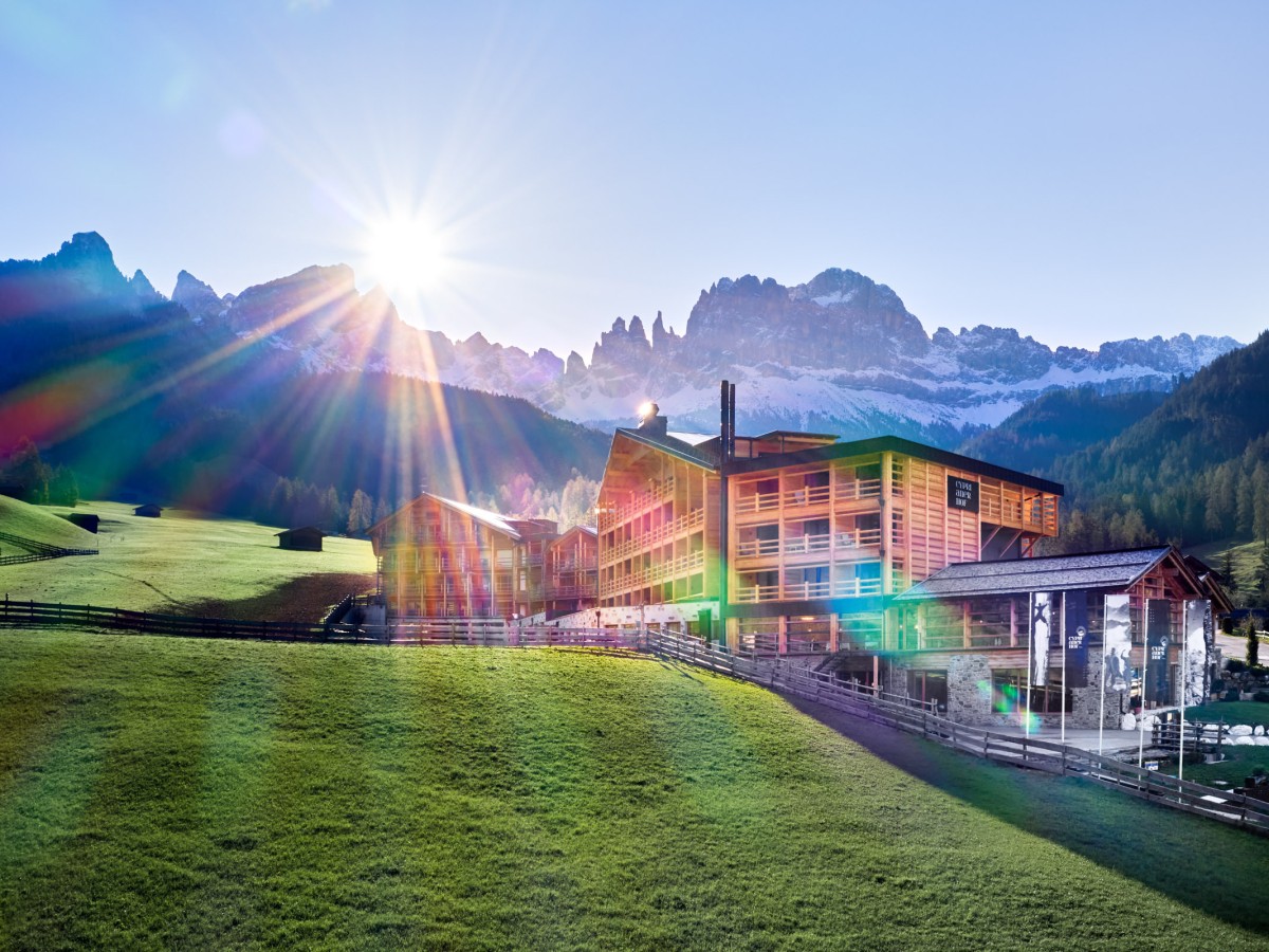 Alpin Hotel mit Sonne im Hintergrund