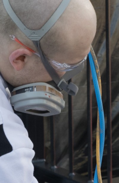 Mann streicht Geländer mit Metallic Lack