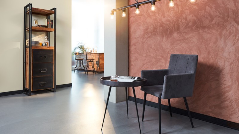 Sessel vor roter Wand mit Mustern
