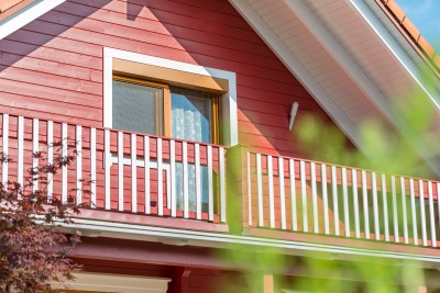Wohnhaus rote Holzfassade und Balkon