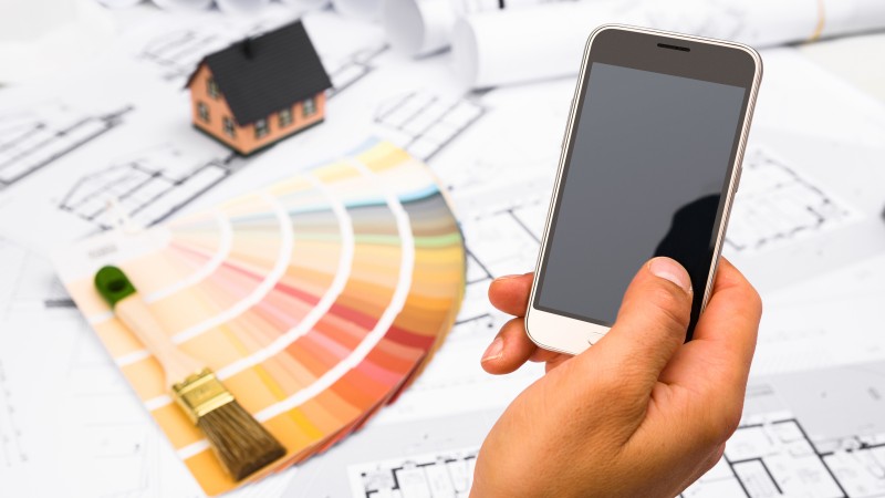 Handy in der Hand, Farbskala im Hintergrund