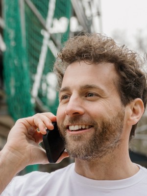 Mann telefoniert auf einer Baustelle mit Kunden zur Beratung