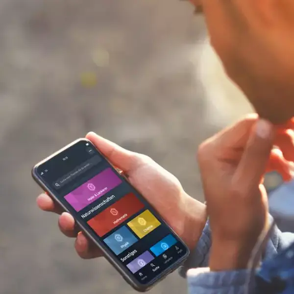 Azubi hält Handy mit geöffneter Simple Club Brillux App 