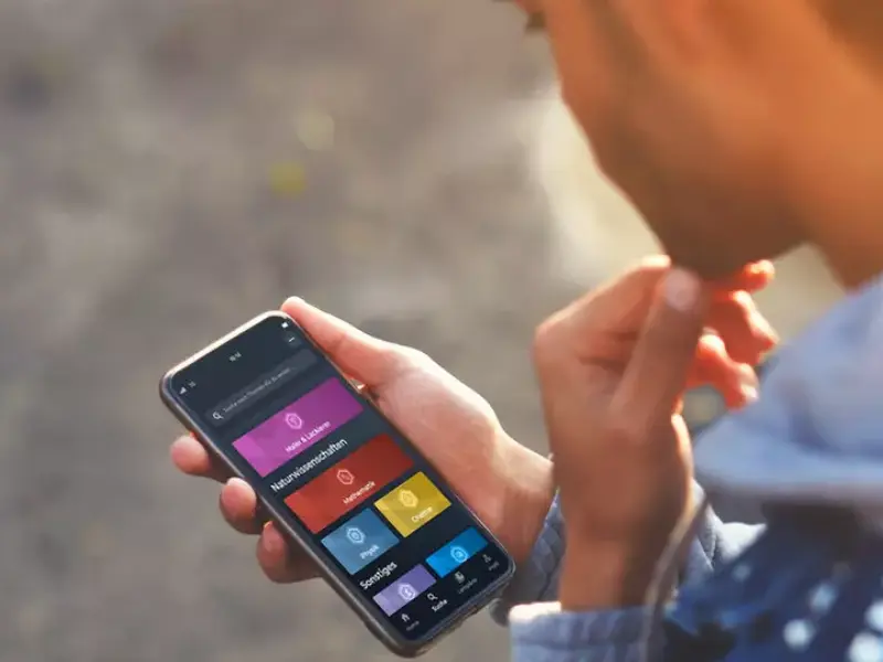 Azubi hält Handy mit geöffneter Simple Club Brillux App 