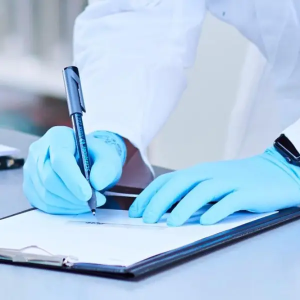 Hände mit blauen Handschuhen schreiben was auf