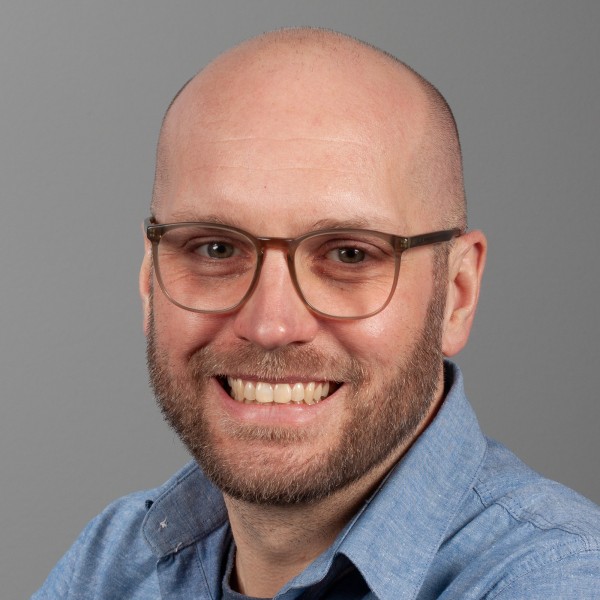 Ein Mann mit Brille und Glatze